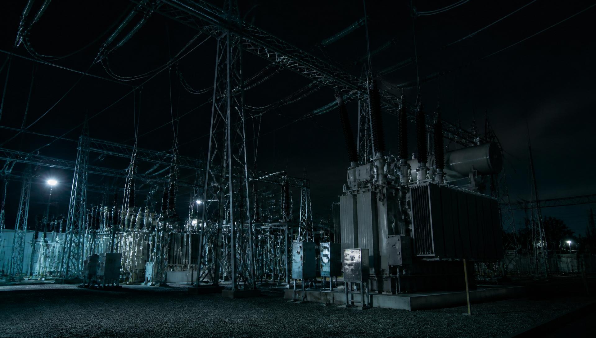 Subestação elétrica de alta tensão fotografada à noite. Imagem ilustrativa de conceito institucional.